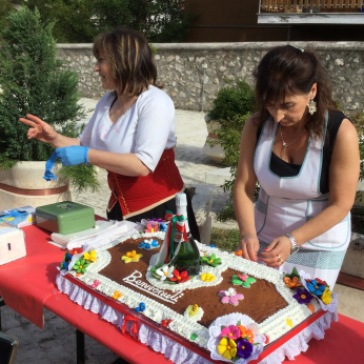 Ladies cutting il pizzillato, a traditional cake at Campo di Giove.